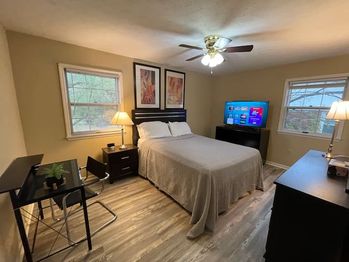 Queen‑size na higaan, flat screen TV, munting mesa, maraming storage
