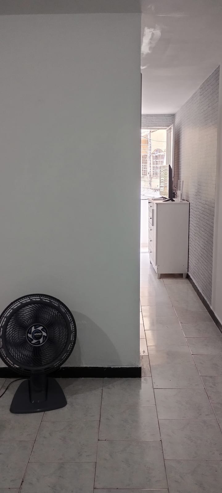 חלק מהסלון עם גישה לחדר רחצה, חדר שינה ומרפסת.