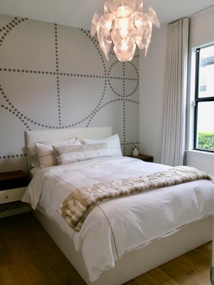 Dormitorio en la primera planta con cama tamaño queen, cómoda de 6 cajones y mesitas de noche dobles, sin armario ni acceso para colgar.