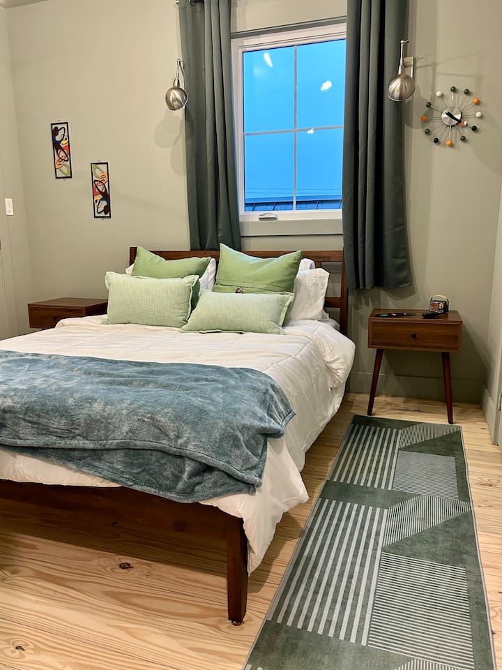 This bedroom comes with a queen bed and is located closest to the full bathroom upstairs. "The MCM" includes blackout curtains and overhead sconces.