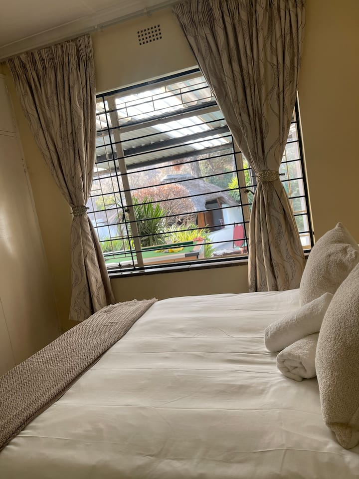 غرفة نوم في الطابق السفلي بسرير مزدوج، وإطلالة على حمام السباحة