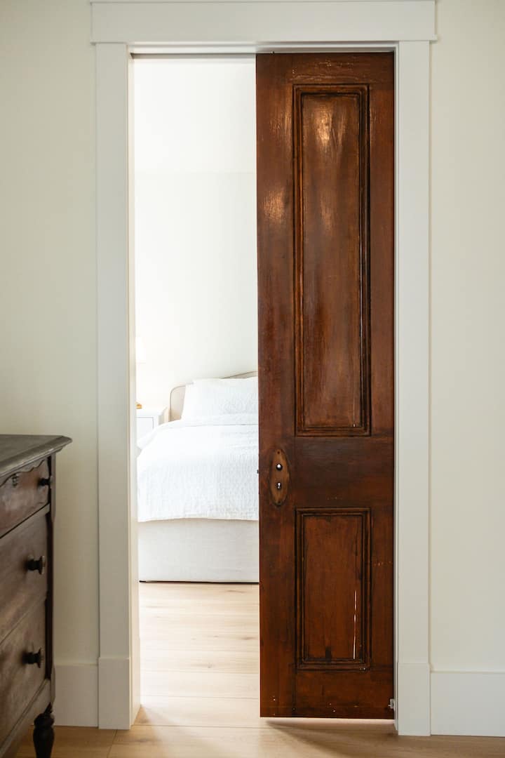 Bedroom 1 is a two bedroom suite. Upon entering the room is a queen bed with a antique dresser and large closet. There is a pocket door leading to a king bed and full ensuite bathroom.