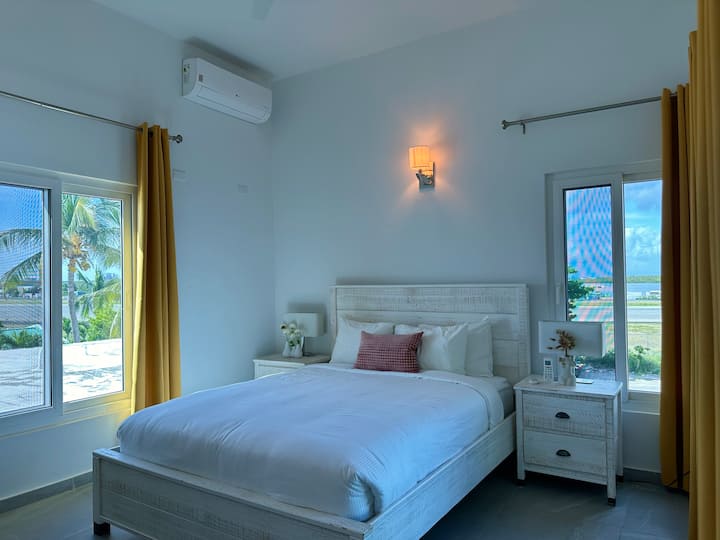 La chambre avec vue sur le jardin offre une retraite paisible, avec de grandes fenêtres qui laissent entrer la lumière naturelle et mettent en valeur la beauté sereine du jardin luxuriant juste à l'extérieur.