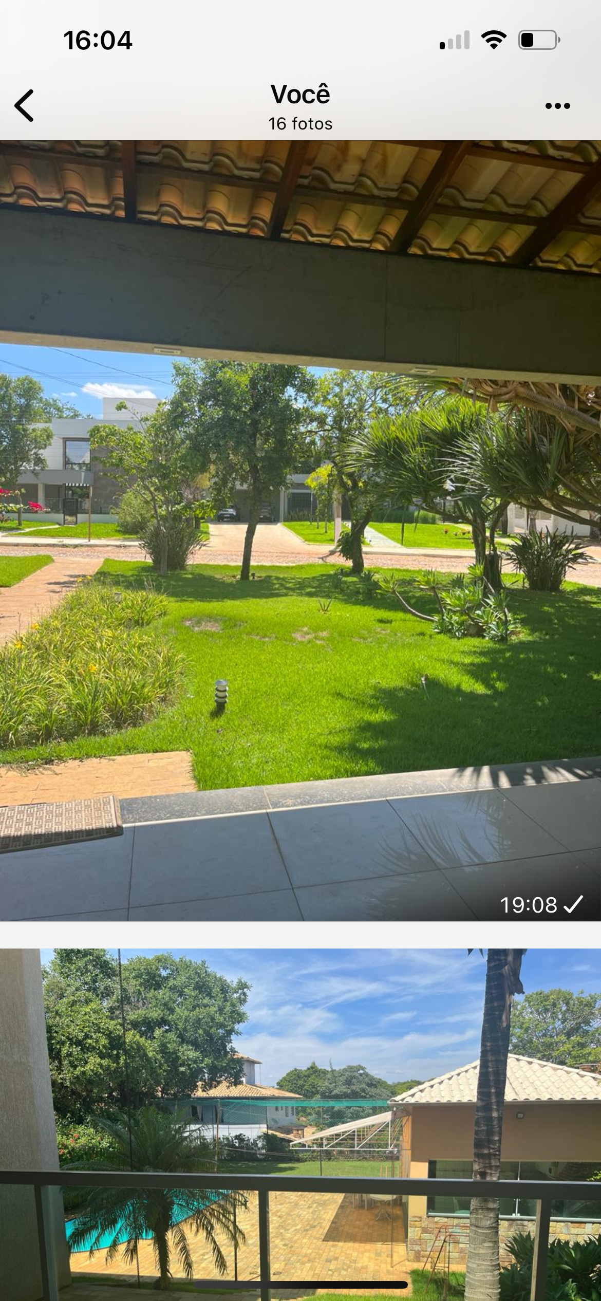 A serene outdoor view captures a lush, green lawn surrounded by well-maintained pathways and diverse trees. The area is bathed in natural light, creating a peaceful atmosphere. The image includes shaded seating areas ideal for relaxation.