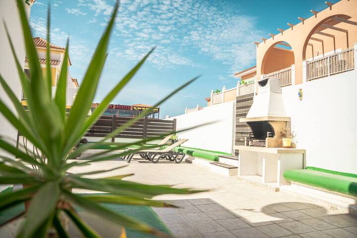 Zona exterior con barbacoa, tumbonas y plantas: ideal para pasar el día fuera.