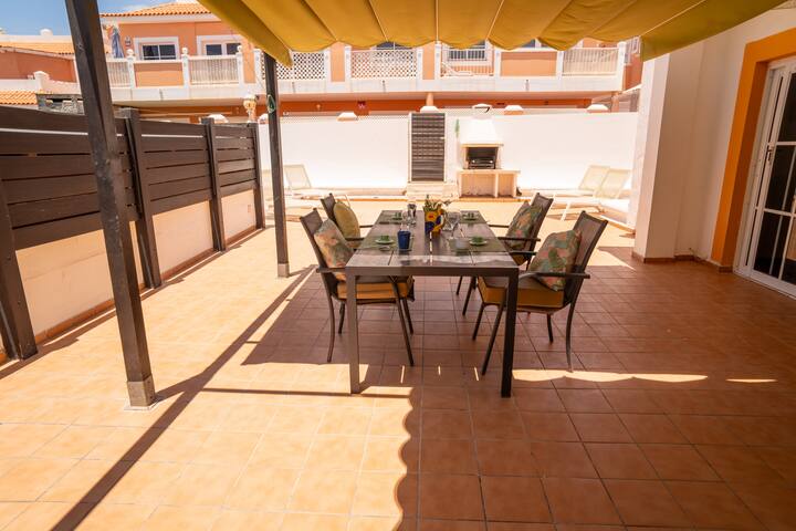 Comedor en la terraza cubierta con mesa amplia para varios comensales: comidas al aire libre.