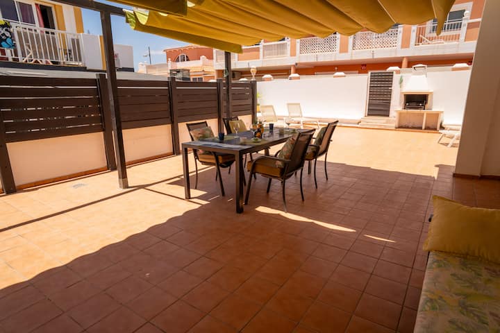 Amplio patio con zona de comedor y barbacoa al fondo: espacio ideal para disfrutar del buen tiempo.