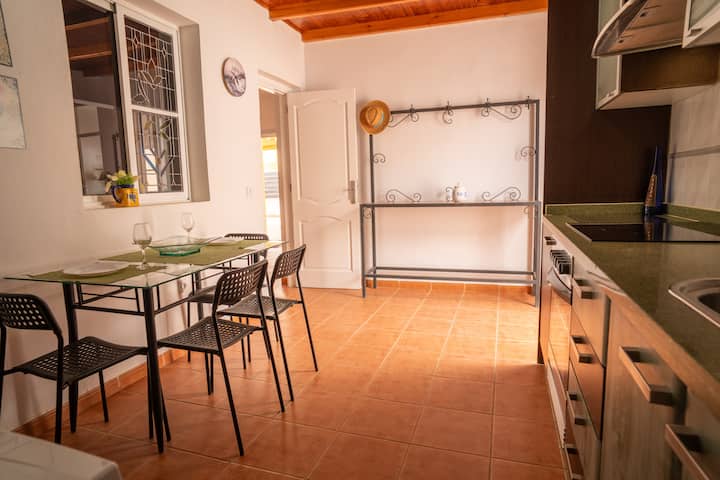 Cocina abierta al comedor con vitrocerámica y mesa: cocina y come sin salir de la estancia.