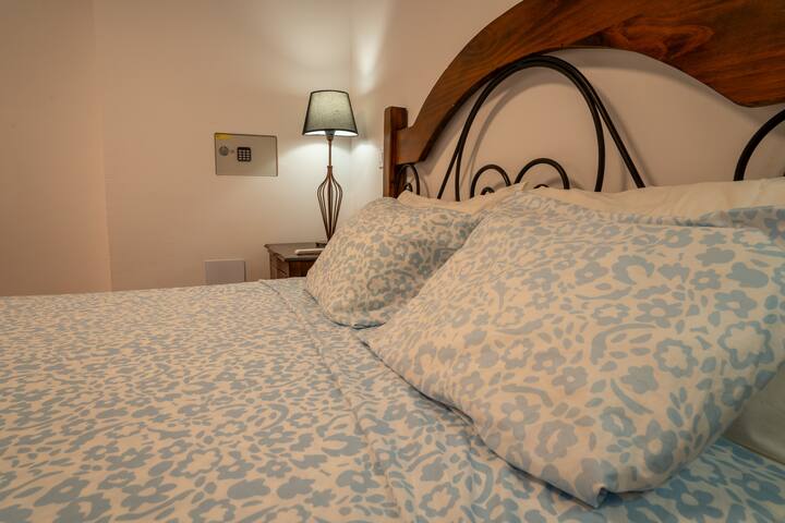 Detalle de la cama de matrimonio del dormitorio 1 con ropa de cama en tonos azules: descanso asegurado.