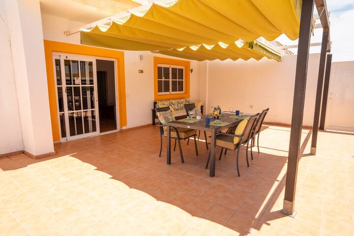 Terraza con mesa y sillas junto a la vivienda: perfecta para comidas y sobremesas al aire libre.