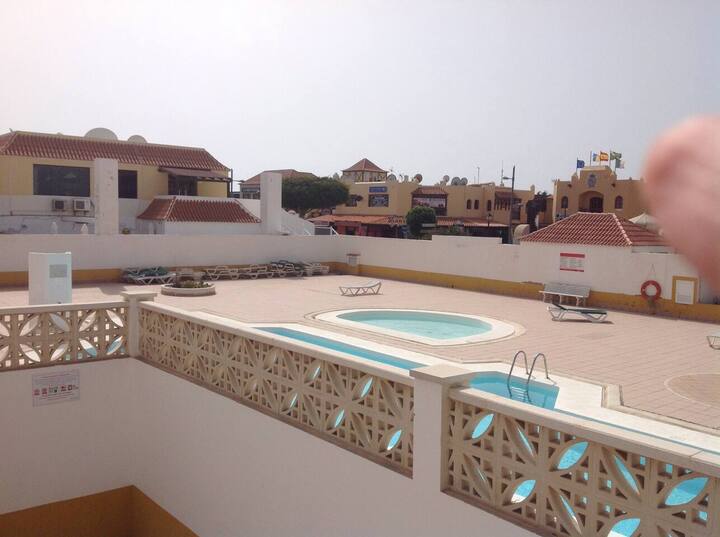Vistas desde la terraza a la piscina y las casas de la urbanización: ambiente tranquilo y luminoso.