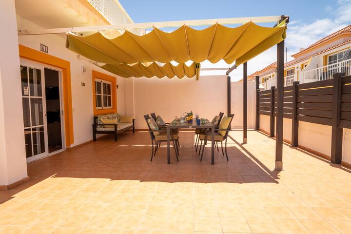 Terraza con toldo y mesa para comer a la sombra: perfecta para disfrutar del clima canario.