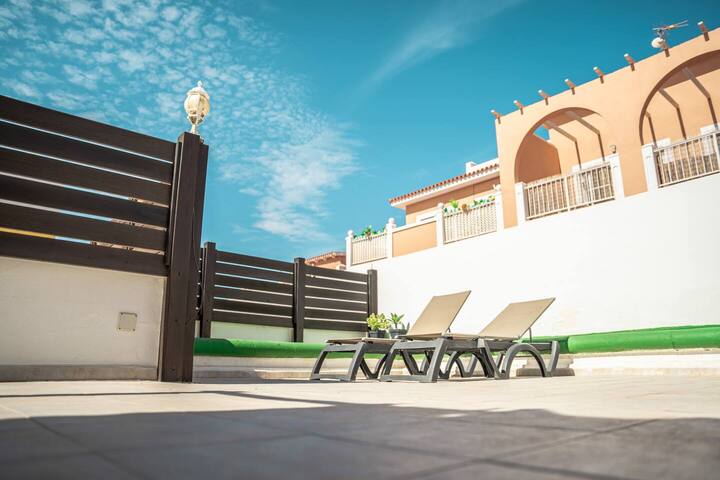 Terraza soleada con tumbonas junto al murete: relax total bajo el cielo canario.