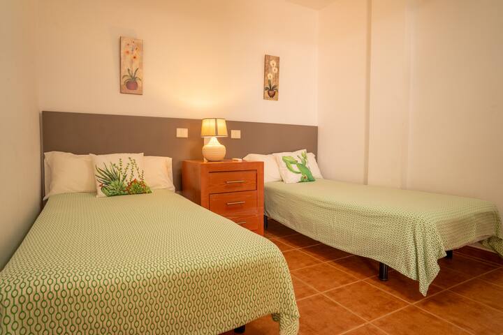 Dormitorio 2 con cama de matrimonio y cama individual, mesilla y lámpara: cómodo para toda la familia.