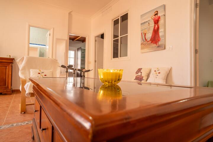 Detalle del salón con mueble de madera y frutero de cristal: toques mediterráneos por toda la casa.