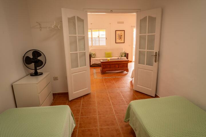 Dormitorio 2 con puertas acristaladas al salón y ventilador: espacio luminoso y ventilado.