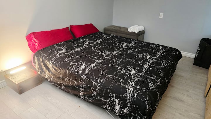 מיטת קינג סייז ושני שידות לילה.