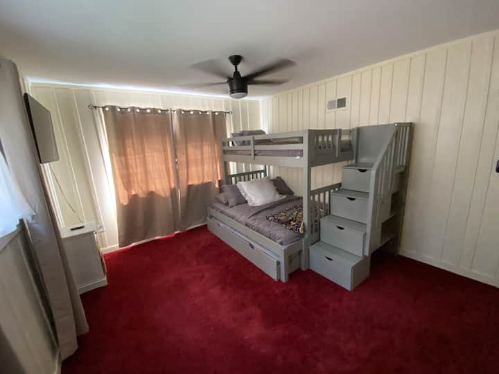 Ampia camera da letto al piano superiore con letto a castello. Il letto a castello include un letto matrimoniale, due letti singoli in cima e un letto estraibile estraibile a due piazze sul fondo. 