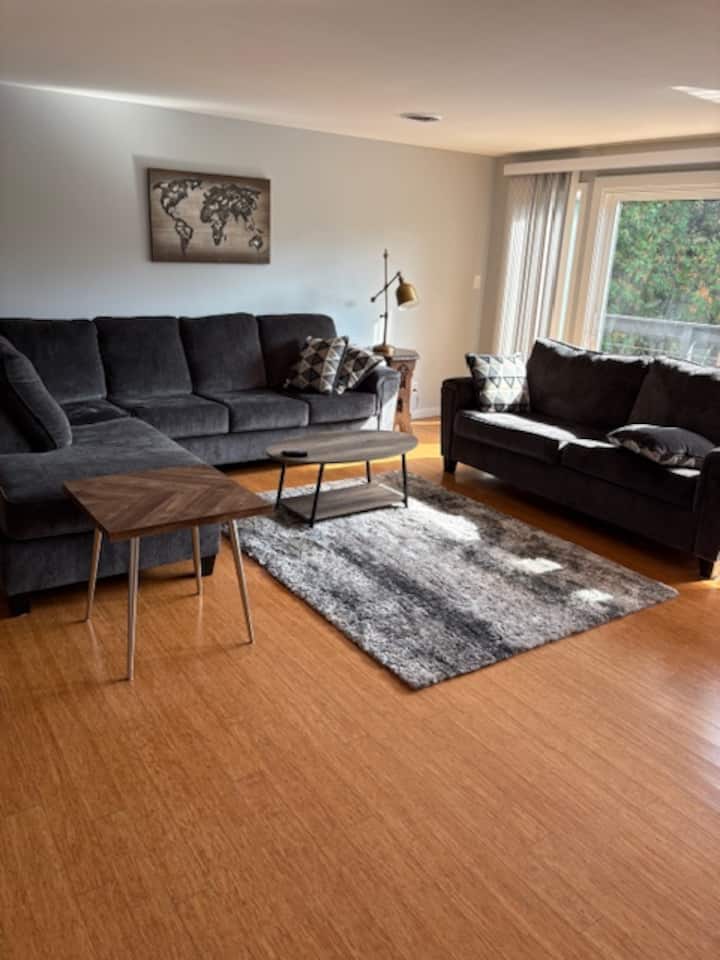 Sebule ya ghorofa kuu.  Kitanda cha sofa, televisheni ya Roku, roshani inayoelekea kwenye bustani