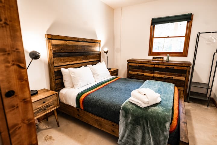 Rustige hoofdslaapkamer beneden – Drijf in een rustgevende slaap op een pluche bed en uitzicht op de vijver. 