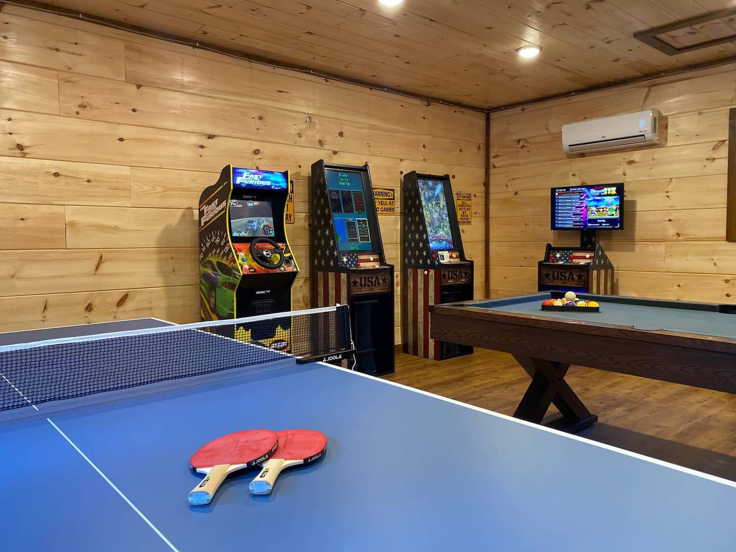 Game room with ping pong, arcade machines, and pool table