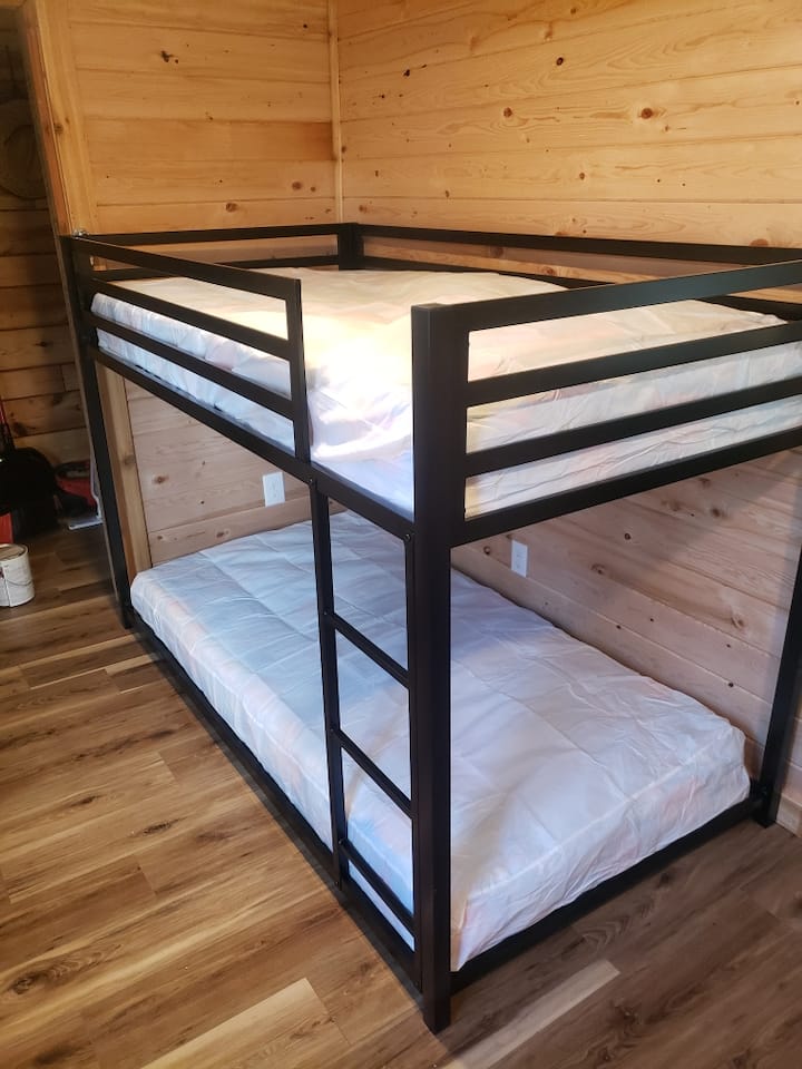 Ორსართულიანი საწოლები ძირითადი საცხოვრებელი სივრცეებისგან კარით გამოყოფილ სივრცეში