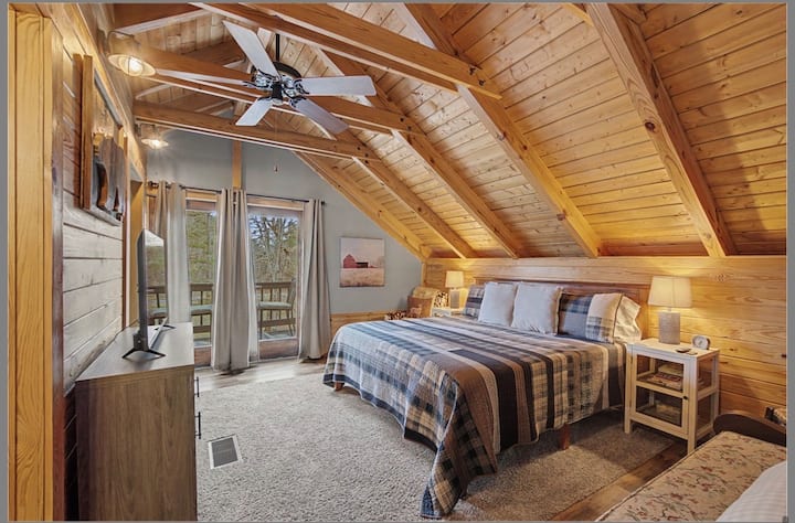 King-sized bedroom with electric fireplace and private balcony