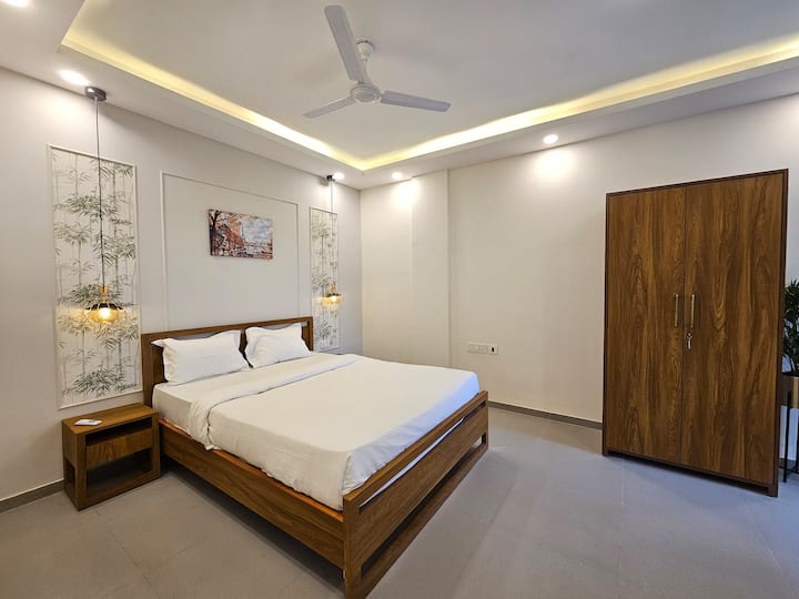 استيقظ منتعشًا في غرفة نوم مضاءة بأشعة الشمس تتميز بفراش ناعم ومساحة خزانة واسعة وتصميم بسيط هادئ