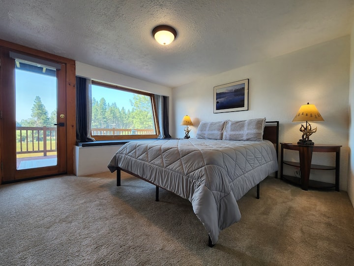 Главна спална соба со приватен влез кон терасата со поглед кон ливадата и реката Дешутес веднаш зад неа.