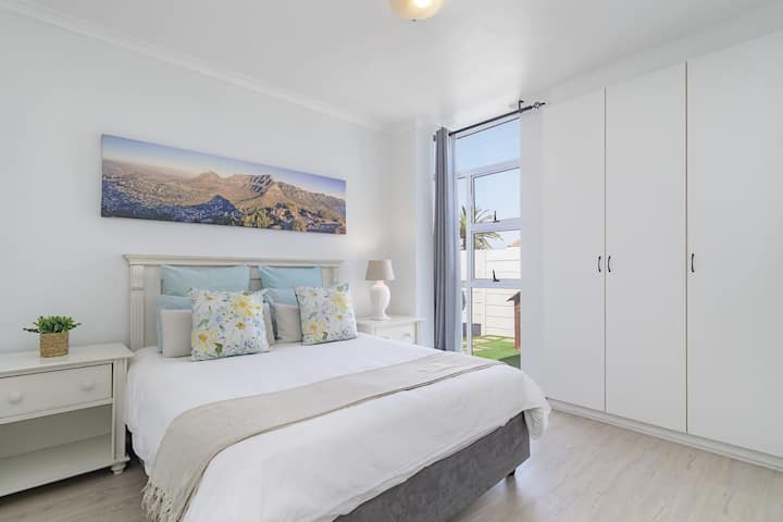 Светла основна спалня с двойно легло, меки чаршафи и достъп до градината за спокоен престой край брега.