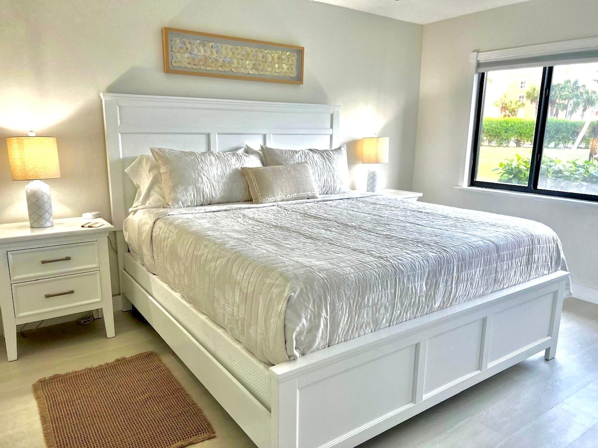 Spálňa s manželskou posteľou King a dvoma elegantnými nočnými stolíkmi s mramorovou strechou.