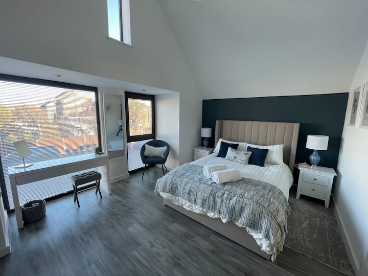 חדר שינה ראשי עם תקרה קמורה, מיטת קינג סייז, חדר צמוד עם מקלחת גדולה.