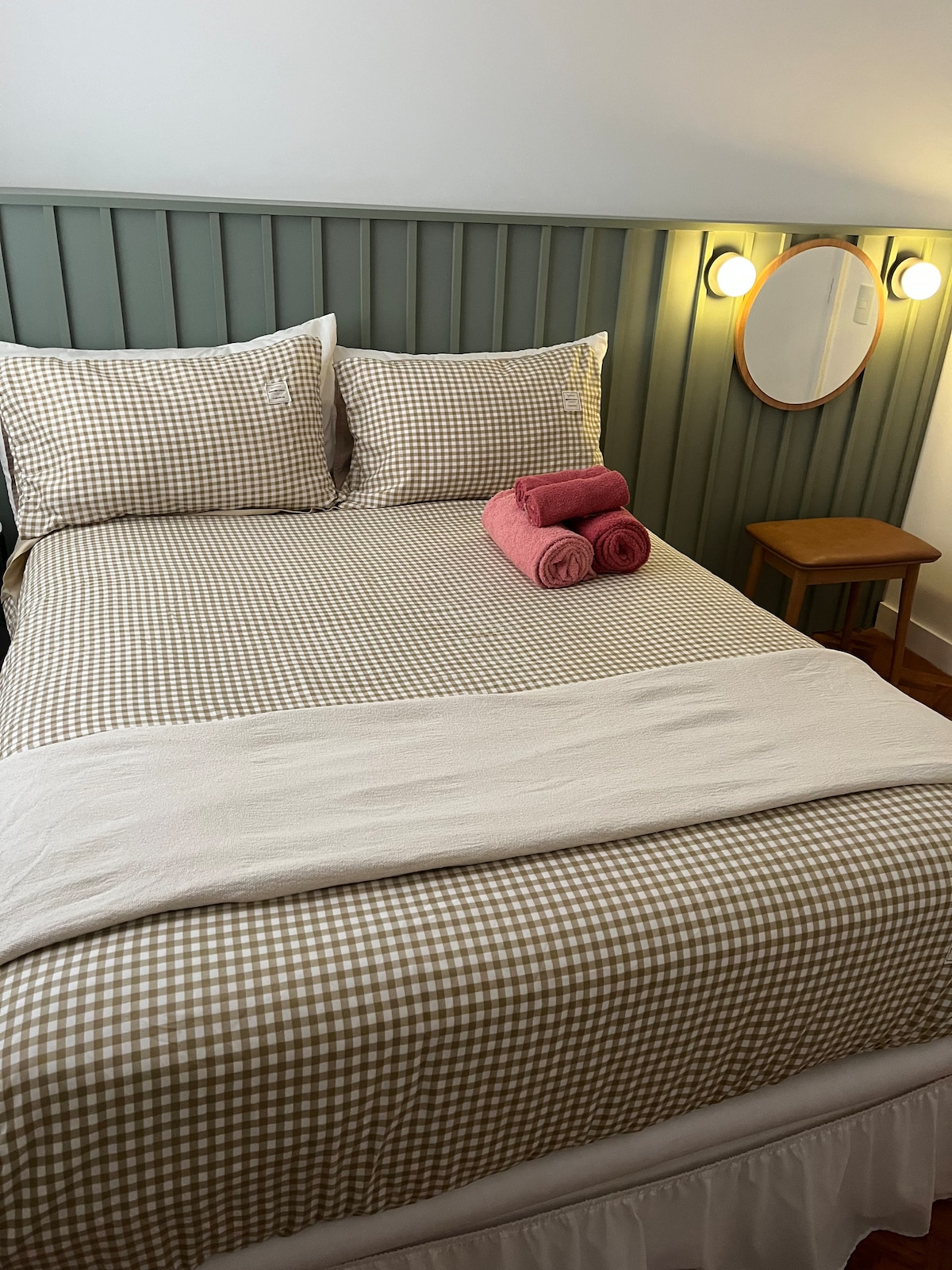 Chumba cha kulala chenye kitanda cha watu wawili, kiyoyozi, makabati na vioo, katika mazingira mazuri na yaliyowekwa.