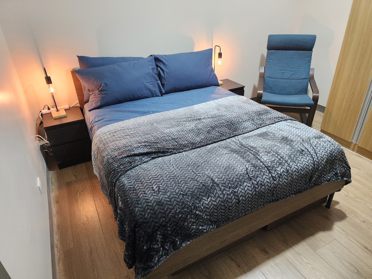 غرفة نوم خاصة واسعة بسرير ناعم بحجم متوسط وإضاءة دافئة على طراز الفندق.