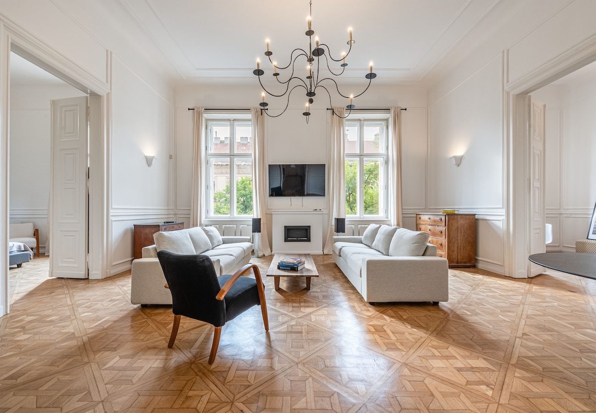 Primera foto de la sala de estar renovada con parqué estilo ópera, chimenea, televisión inteligente y sofás nuevos, antes de que llegue la alfombra bereber original. 