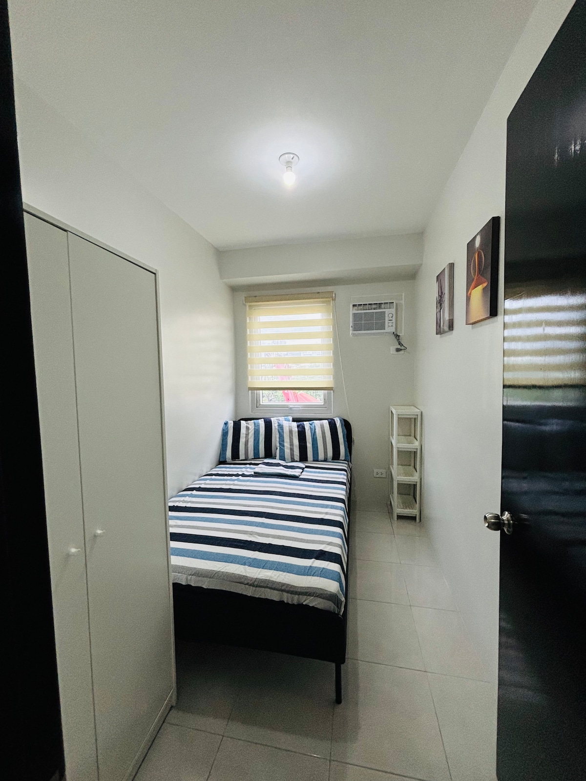 يوجد سرير مزدوج الحجم بدقة في الغرفة، مقترنة بخزانة أنيقة للتخزين. يقع بالقرب من النافذة، ويسمح للضوء الطبيعي بإضاءة المسكن، مما يخلق أجواء جيدة التهوية ومريحة. 