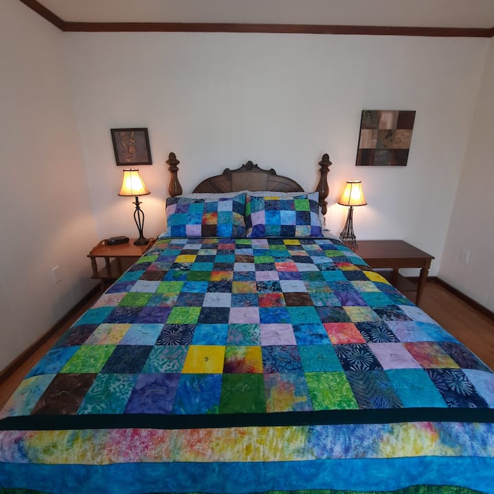 Chambre de belle taille. Lit queen avec grande table de nuit. 