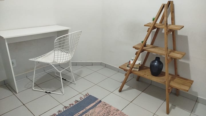 חדר המשמש כמשרד, עם שולחן כתיבה, כיסא, ספה קטנה ומאוורר תקרה