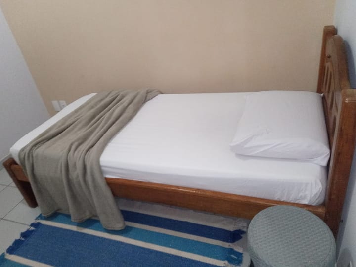 חדר שינה עם מיטת יחיד ומאוורר תקרה