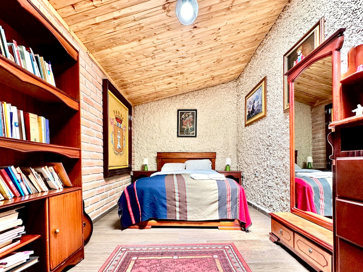 חדר שינה ראשון עם מיטת קווין סייז, ארון ושמיכות נוספות.