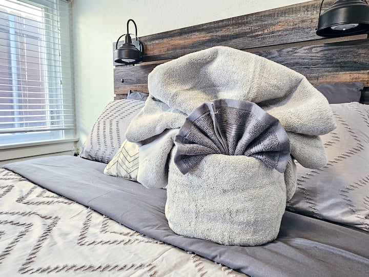 - Close up of unique towel arrangement on the rustic bed frame  
- Adds a personal touch to the guest experience with décor  
- Thoughtful details create a warm and inviting San Diego stay  
