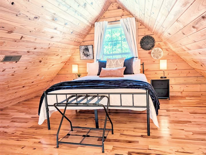 Eneo hili la kulala la roshani lililo wazi linatoa sehemu nzuri yenye mandhari nzuri ya nyumba. Ingawa si chumba cha kujitegemea, kinatoa sehemu nzuri ya kupumzika huku kikiendelea kuunganishwa na maeneo makuu ya kuishi. Mapazia ya giza ya chumba husaidia kudhibiti mwanga.