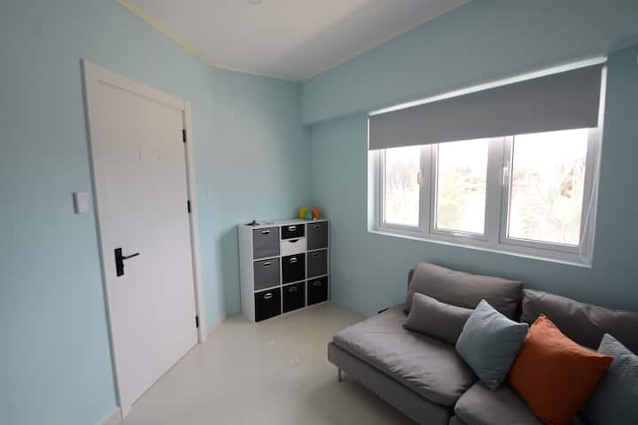 La chambre comprend un lit superposé, un espace de rangement pour les bagages et un canapé. 