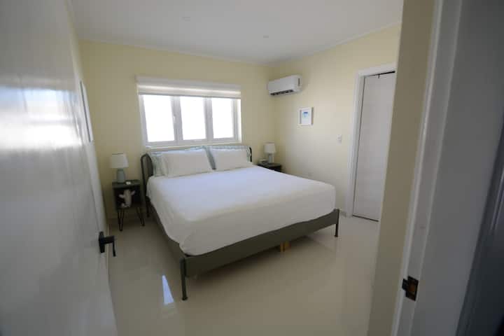 Cette chambre avec lit king size comprend un lit confortable, une armoire et une salle de bain complète. 