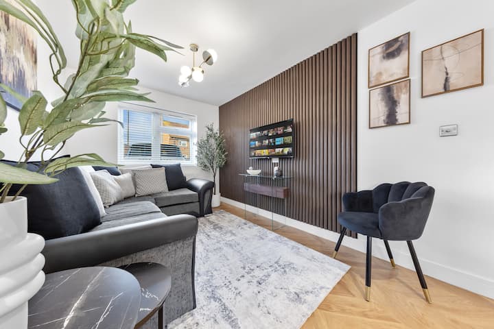 Un salon moderne avec un canapé moelleux et une télévision élégante, créant un espace confortable pour se détendre. Une table à manger élégante ajoute de la fonctionnalité, ce qui la rend parfaite pour les divertissements et les repas.
