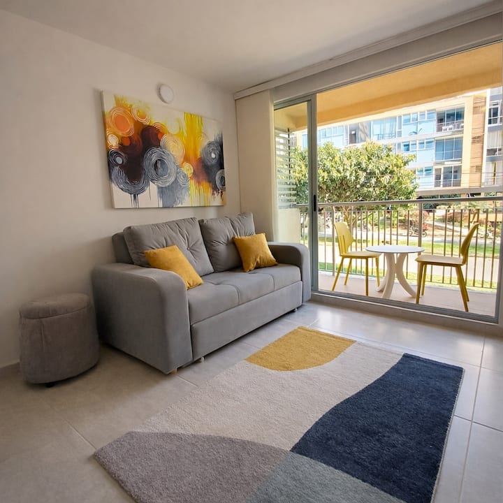 Sala luminosa con acceso directo al balcón, ofreciendo un ambiente acogedor y relajante. El sofá es cómodo y perfecto para descansar después de un día explorando la ciudad.