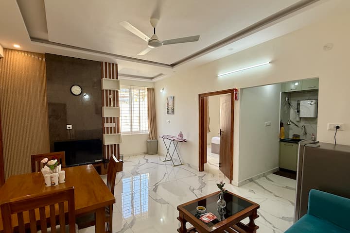 Priestranná obývacia a jedálenská časť s elegantnou podlahou, moderným osvetlením a pripojenou kuchyňou. Navrhnuté pre pohodlie, komfort a uvoľnený každodenný život.