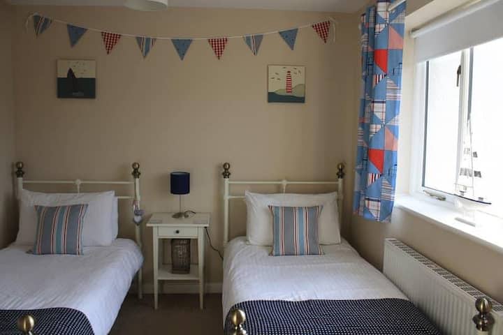 Spálňa s oddelenými posteľami s výhľadom na zadnú záhradu a potok