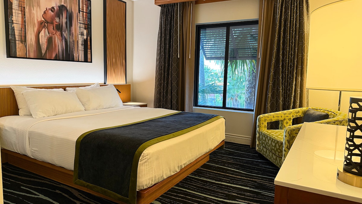 Dormitorio con cama tamaño king y ropa de cama premium.