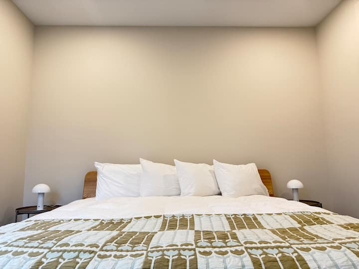 Dormir con estilo.  Nuestra cama tamaño king ofrece una comodidad inigualable, combinada con almohadas suaves, iluminación cálida, creando un refugio sereno para una noche de sueño reparador. 